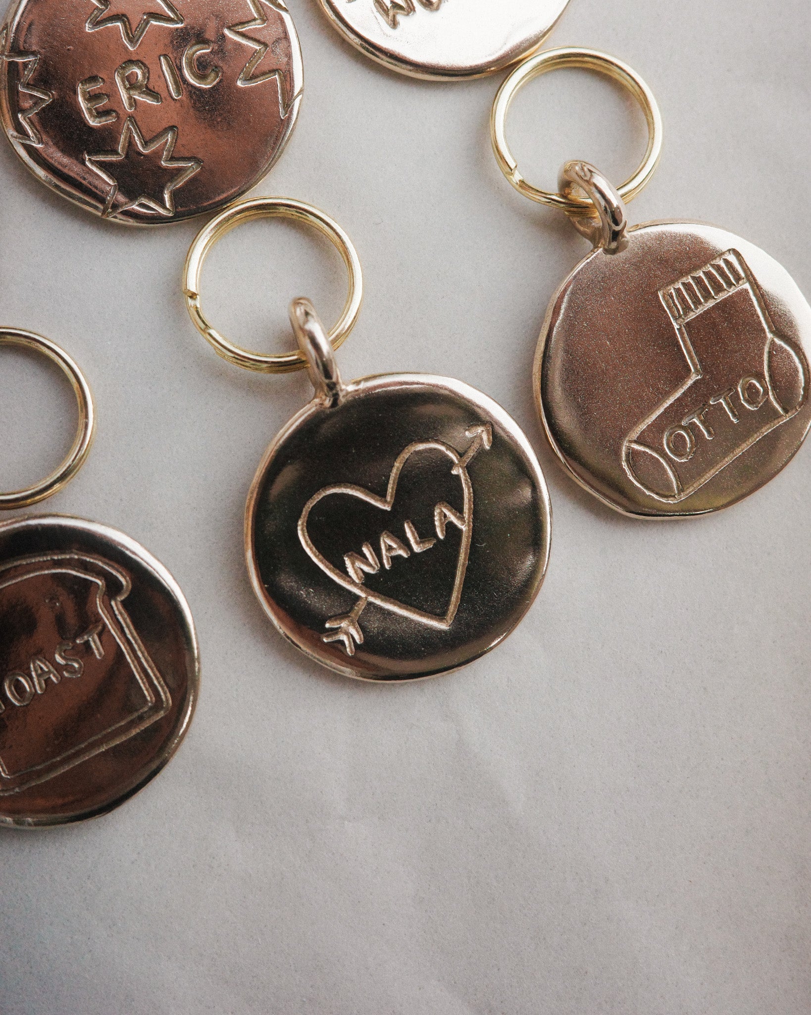Unique bespoke pet tags with character. Customised custom pet ID tags with doodles matching your pets personality. Hand carved round circle coin in solid brass 