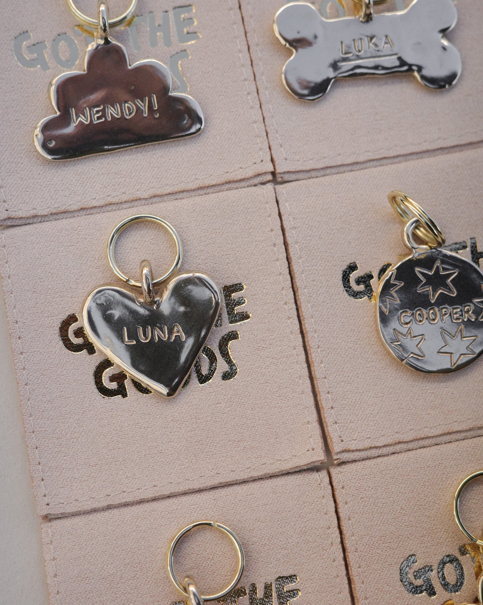 Got the goods pet supplies. Unique cool fun pet tags and ideas. Custom round coin circle pet tag in brass. Cloud heart bone shaped. Hand carved with dogs name and stars doodles unique and playful bespoke pet tags for dogs and cats.